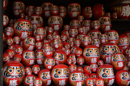 Stack of many red daruma dolls on wooden shelf in Katsuo-ji temple, Minoh, Osaka, Japan. The Kanji translated to English : "Victory"の写真素材
