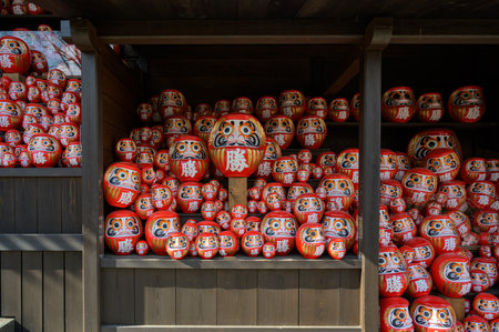 Stack of many red daruma dolls on wooden shelf in Katsuo-ji temple, Minoh, Osaka, Japan. The Kanji translated to English : "Victory"の写真素材