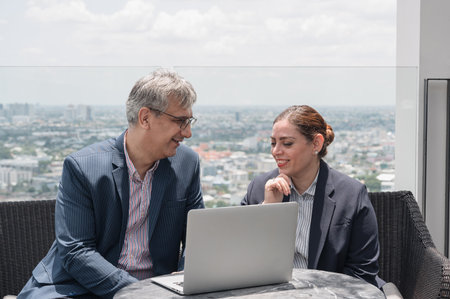 Businessman and businesswoman having business discussion and working together with laptop computer...