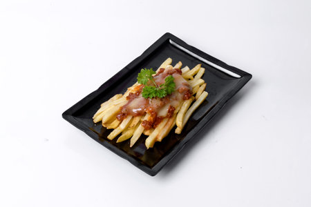 French fries with bbq sauce on a black plate isolated on white background.の写真素材