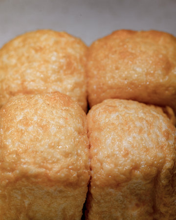 A close up of four golden brown pastries. The pastries are all the same size and shape, and they are...