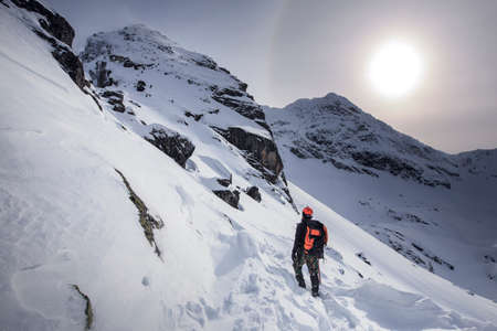 Climber hiking on the mountain in winter. Tatra Mountains with KoÅ›cielec peak. Snowy scenery.
