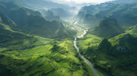 a winding river cutting through a verdant valley surrounded by mountainsの素材