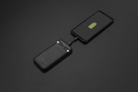 mobile phone charging black powerbankの写真素材