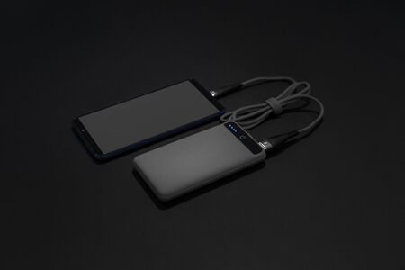 mobile phone charging gray powerbankの写真素材