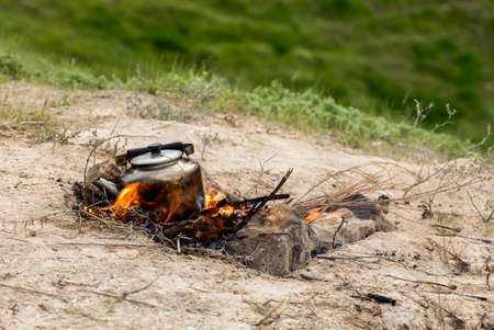 Teapot in Iraqi countryside with burnig wood under itの写真素材
