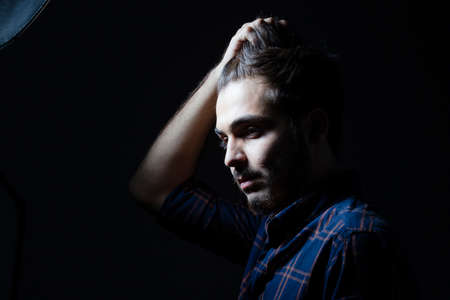Boy in darkness isolated inside Studio