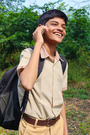 Clever schoolboy raising his trophy as a winner in school competition.の写真素材