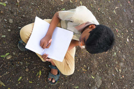 Clever schoolboy raising his trophy as a winner in school competition.の写真素材