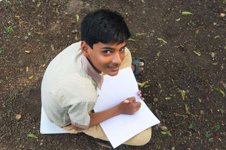 Clever schoolboy raising his trophy as a winner in school competition.の写真素材