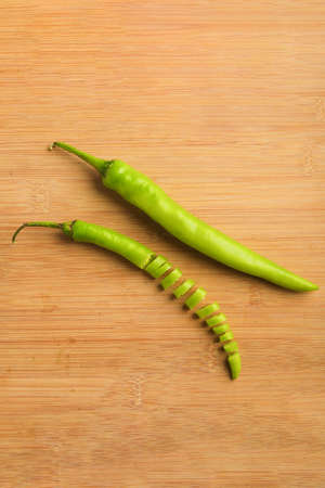 green chili slices on white board.の写真素材