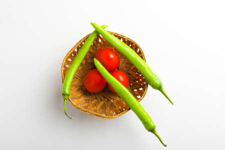 Fresh Green chilli and tomatos on white background.の写真素材