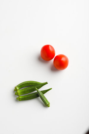 ladyfinger and red tomato on white background.の写真素材