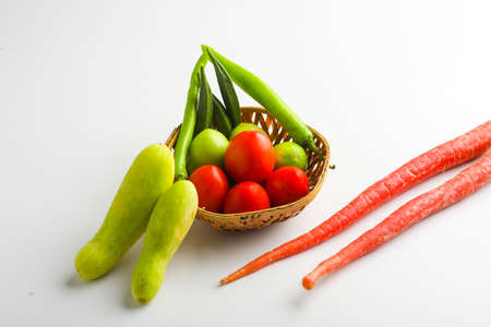 Raw vegetable in wooden bowl on white background.の写真素材