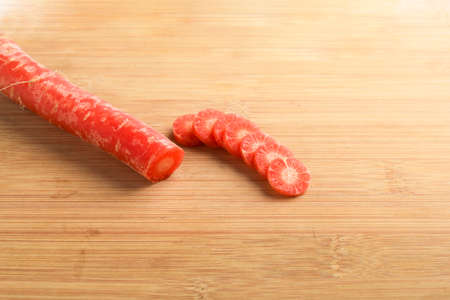 Fresh carrot slices on wooden board.の写真素材