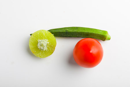 ladyfinger red tomato and indian gooseberry on white background.の写真素材