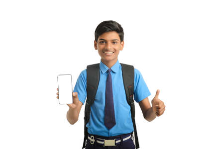 technology concept: Cute indian little school boy showing smartphoneの写真素材