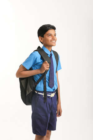 Indian school boy standing on white background.の写真素材