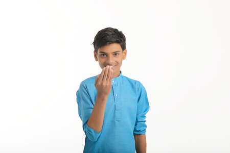 Indian boy in traditional wear and giving hand expression on white background.の写真素材