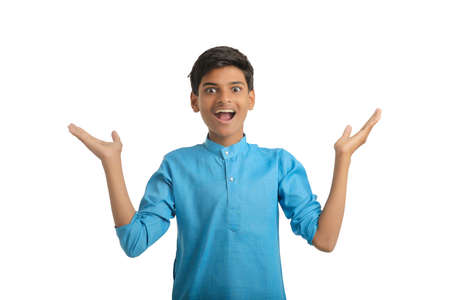 Indian boy in traditional wear and giving hand expression on white background.の写真素材