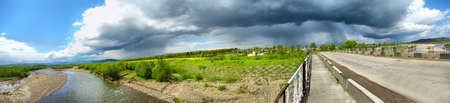 The thunderstorm is getting closer and river and mountains are hereの写真素材