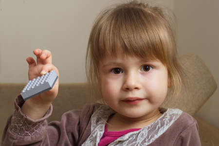 Little girl holding a toy indoorsの写真素材