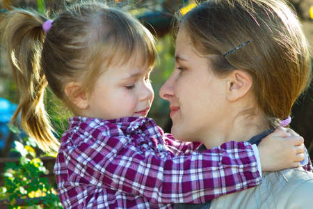 Mother and daughter looking at each other in a sunny dayの写真素材