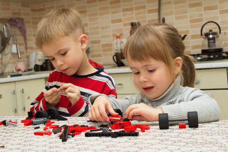Boy and girl are playing with blocks indoorsの写真素材
