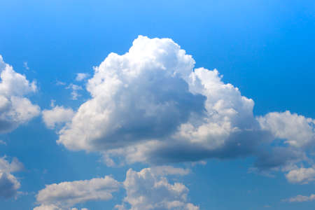 Blue sky with puffy white clouds in bright sunny dayの写真素材