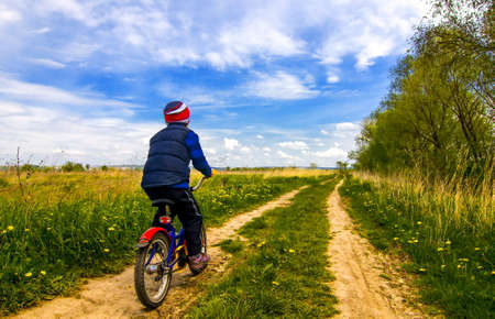 Boy on bike on country road sunny spring dayの写真素材