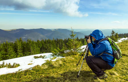 Lonely photographer in mountains taking the picture of a lonely pine treeの写真素材