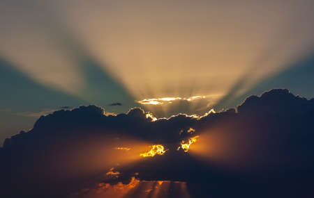 Dramatic sunset sky with beames of light through cloudsの写真素材
