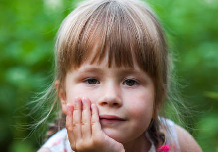 Portrait of a little girl on blurred green backgroundの写真素材
