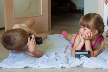 Little boy taking a picture of a little girlの写真素材