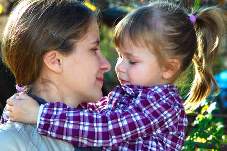 Mother and daughter looking at each other in a sunny dayの写真素材