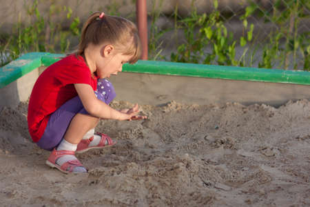 Little girl playing in sandbox on a sunny summer dayの写真素材