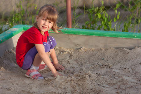 Little girl playing in sandbox on a sunny summer dayの写真素材