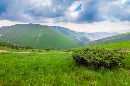 Sharp green mountain peaks and sky with dramatic clouds landscap