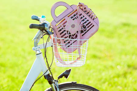 Womans hand bag in bicycle basket sloseupの写真素材
