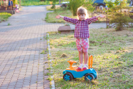 Little cute girl outdoors with a toy car on a sunny dayの写真素材