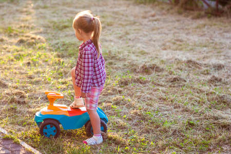 Little cute girl outdoors with a toy car on a sunny dayの写真素材