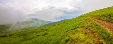Sharp green mountain peaks and sky with dramatic clouds landscape