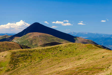 Mountain Hoverla in Carpathians, Ukraine. Beautiful mountain view in summer with green meadow and blue sky.の写真素材