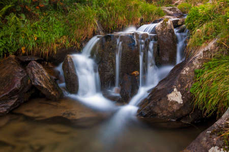 Beautiful waterfall in mountains with white foamy waterの写真素材