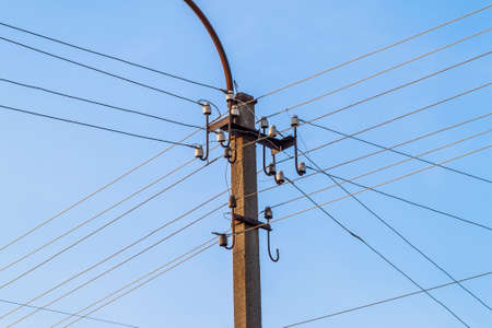 Electric pole power lines and wires with blue skyの写真素材