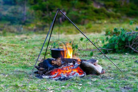 Camping kitchenware - pot on the fire at an outdoor campsiteの写真素材