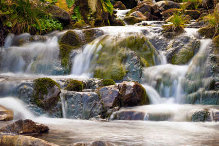 Small Waterfall in park with beautifull smooth water. Little waterfall in mountain forest with silky foaming water.の写真素材