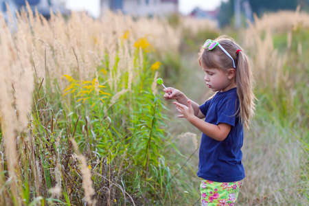 Portrait of little fashionable girl in green sunglasses outdoorsの写真素材