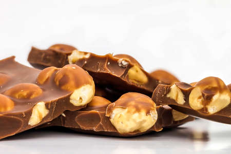 Milk chocolate pieces with whole hazelnuts. Chocolate bar / chocolate background/ nut chocolate / chocolate towerの写真素材