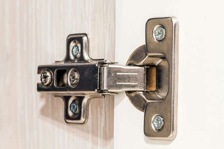 Standard professional hinge for overlay application for all kinds of furniture. Hinge Kitchen assembled on white doors, steel, isolationの写真素材